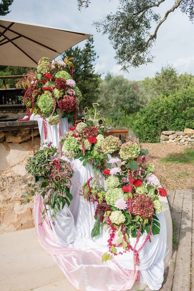 Decoración floral con hortensias y telas rosas para un evento en Ibiza